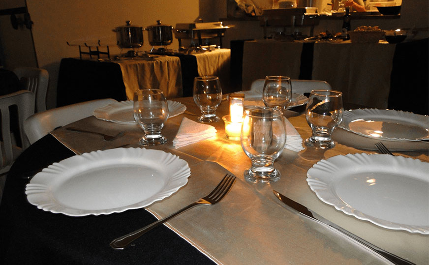 Mesa de buffet de massas com toalha e louças